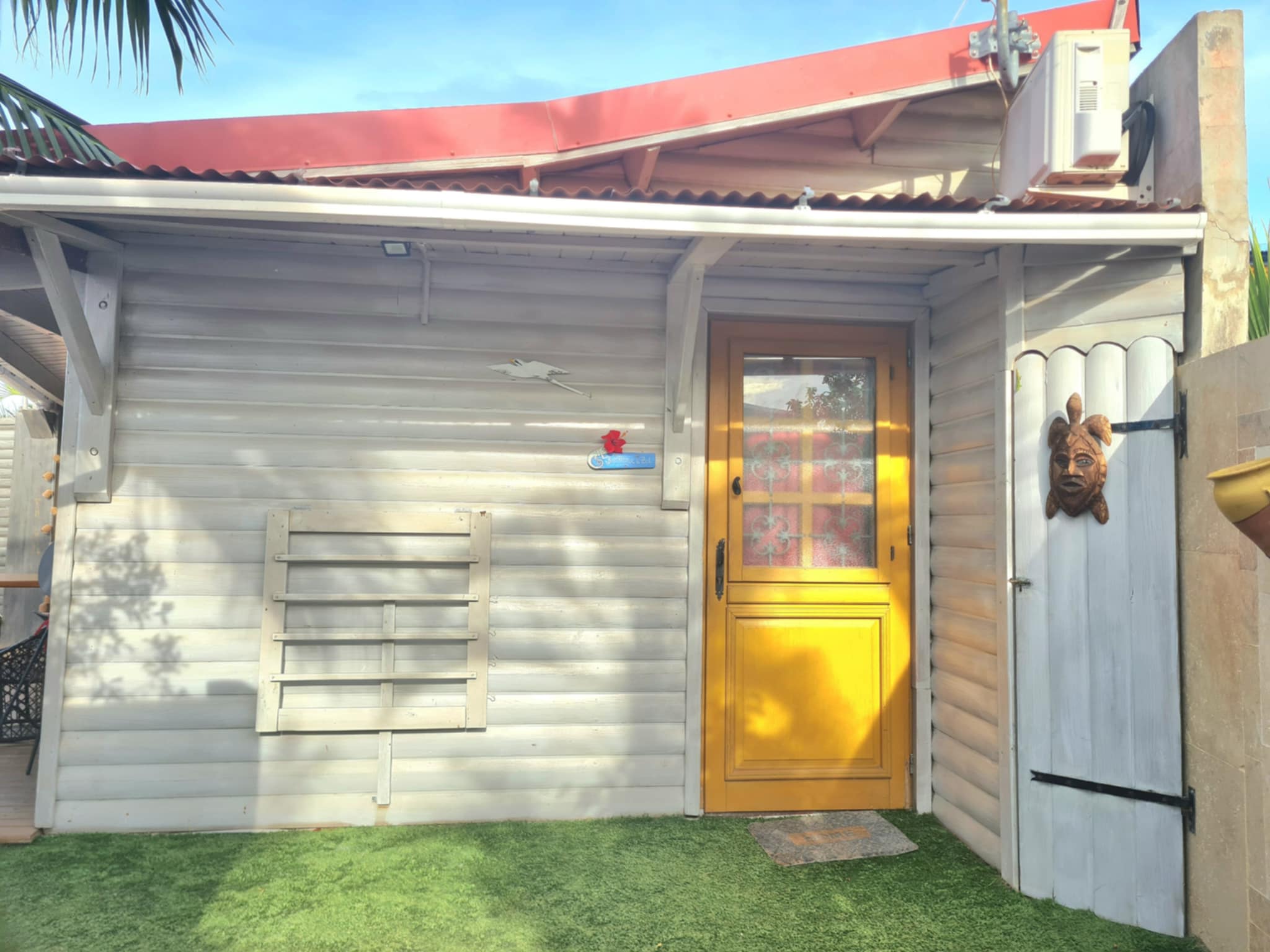 Façade du bungalow créole avec sa porte jaune