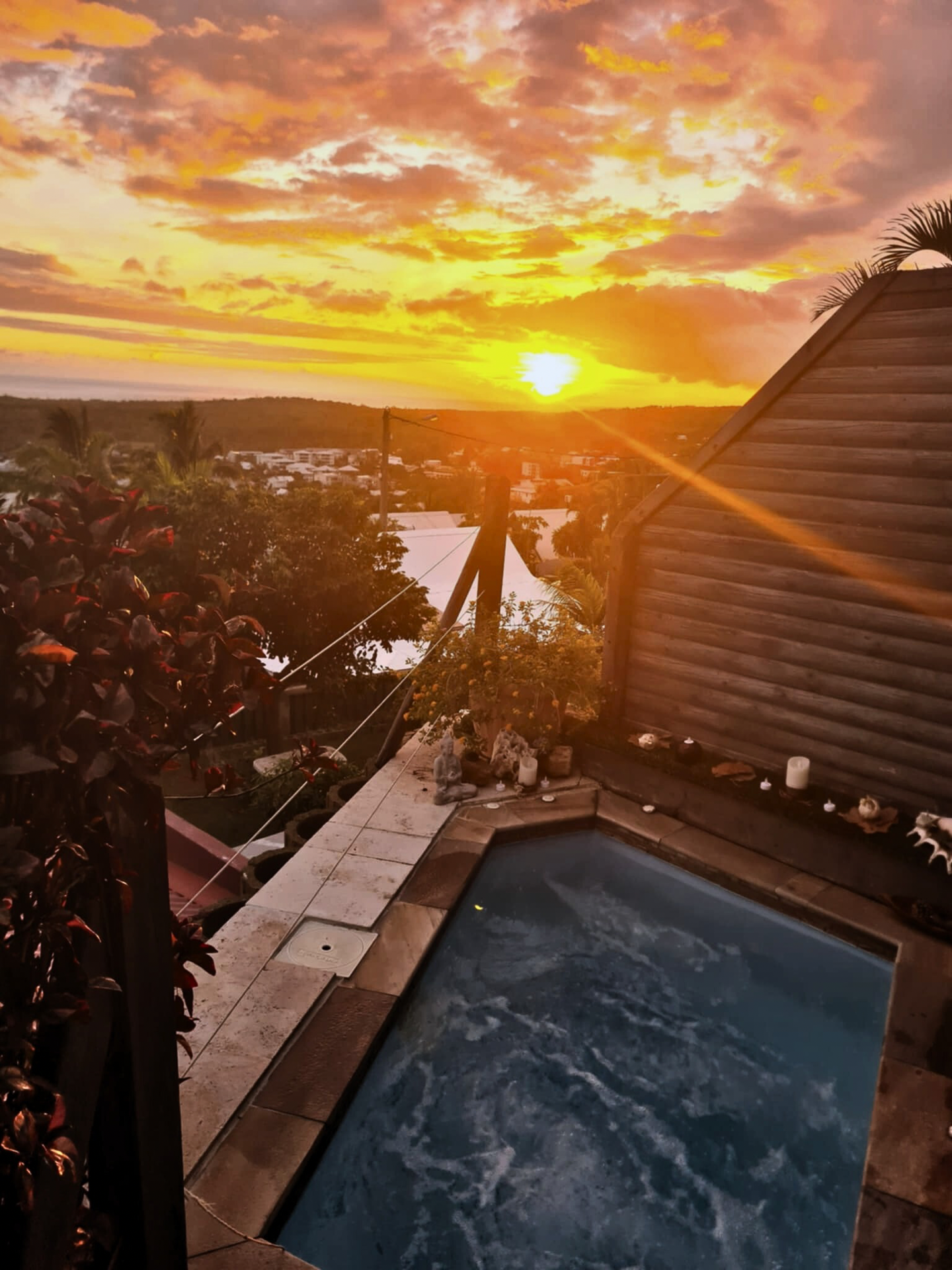 Spa illuminé au coucher du soleil avec bougies